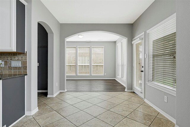 interior space featuring baseboards and light tile patterned floors