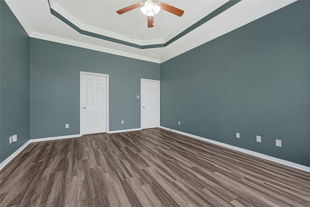 unfurnished room with ceiling fan, crown molding, wood finished floors, baseboards, and a tray ceiling