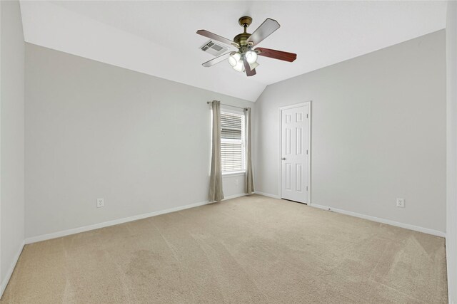 spare room featuring light colored carpet, a ceiling fan, baseboards, and lofted ceiling