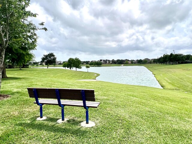 surrounding community with a lawn and a water view