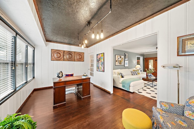 office space with crown molding, dark wood-style flooring, a decorative wall, baseboards, and ceiling fan