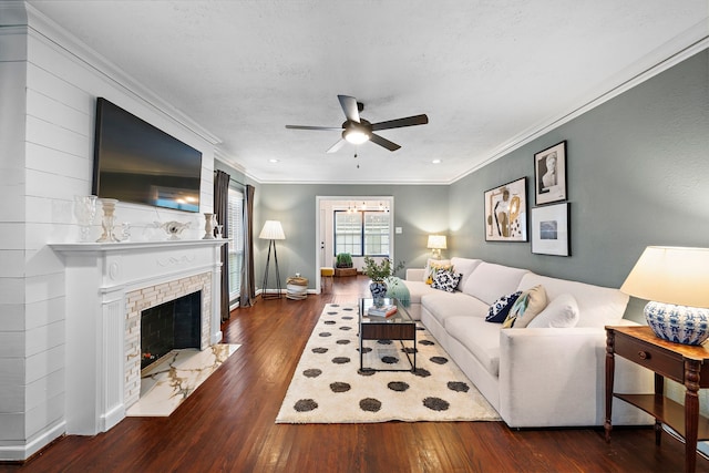 living area featuring wood-type flooring, a ceiling fan, baseboards, and ornamental molding