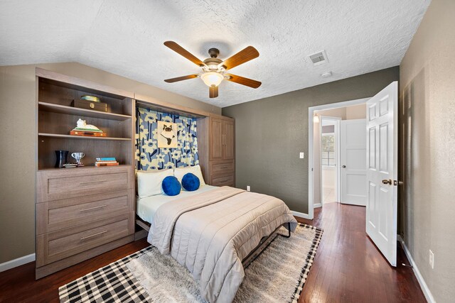 bedroom with dark wood-type flooring, a textured ceiling, and visible vents