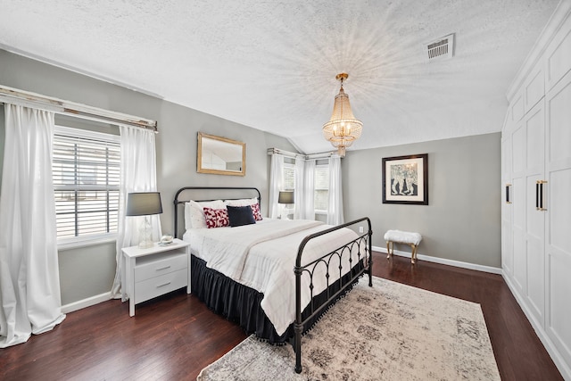 bedroom with baseboards, multiple windows, a textured ceiling, and visible vents