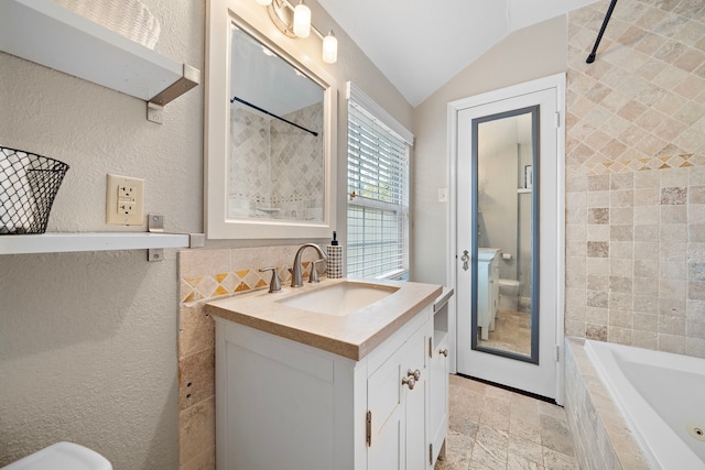 full bath featuring toilet, a tile shower, lofted ceiling, and vanity