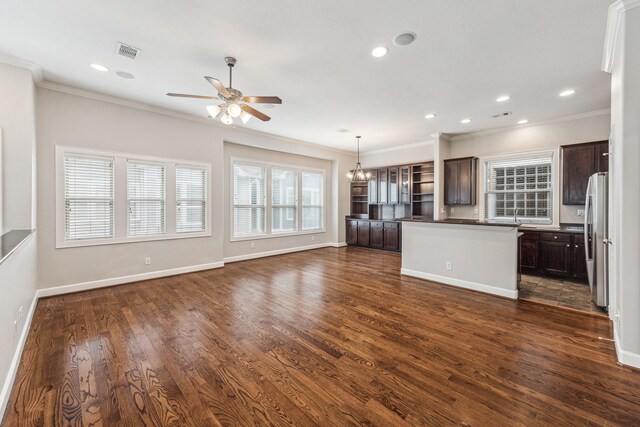 interior space with visible vents, crown molding, ceiling fan with notable chandelier, and dark wood-style floors