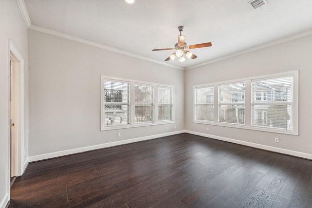 spare room with ceiling fan, visible vents, crown molding, baseboards, and dark wood-type flooring