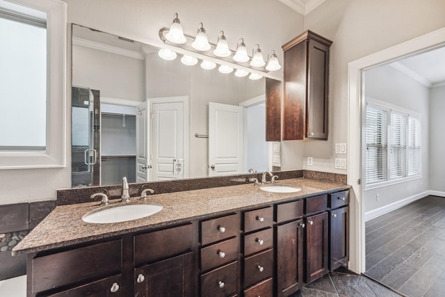 full bath with crown molding, a sink, baseboards, and double vanity