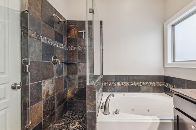full bathroom featuring a whirlpool tub, a stall shower, and vanity