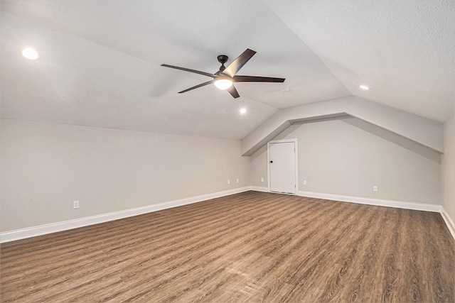 additional living space with lofted ceiling, wood finished floors, baseboards, recessed lighting, and a ceiling fan