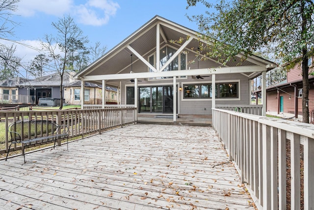 rear view of house with a sunroom, ceiling fan, and a deck