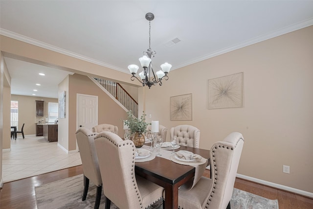dining room with stairway, an inviting chandelier, baseboards, and light wood finished floors