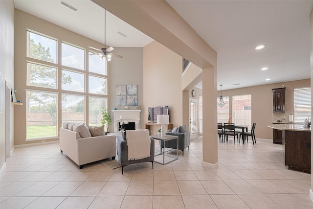 living area with baseboards, visible vents, light tile patterned floors, and a fireplace