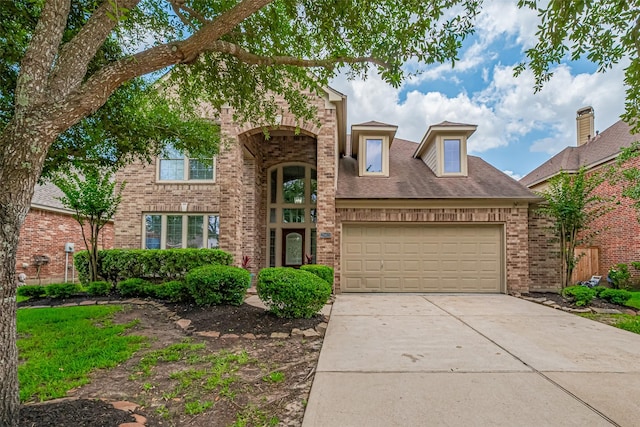 traditional-style house featuring brick siding, driveway, and a garage