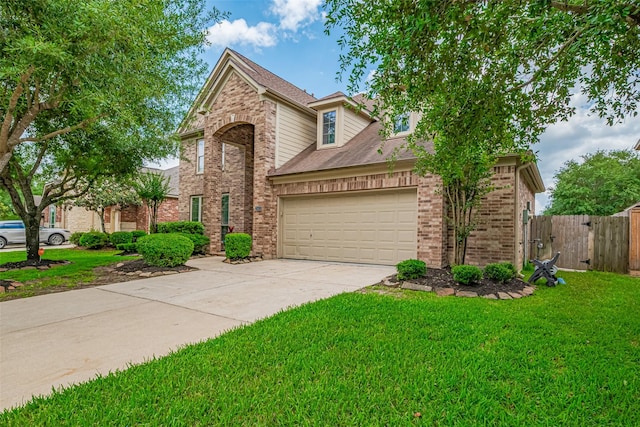 traditional-style house with a garage, a front yard, brick siding, a gate, and driveway