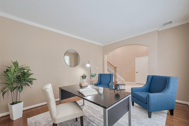 home office with visible vents, arched walkways, wood finished floors, baseboards, and ornamental molding