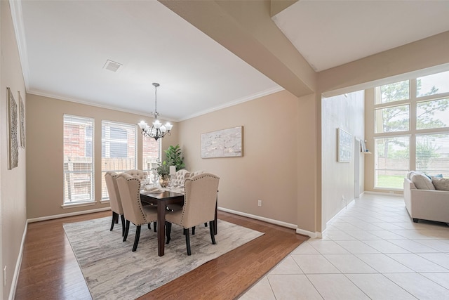 dining area featuring visible vents, ornamental molding, baseboards, light wood-style floors, and a notable chandelier