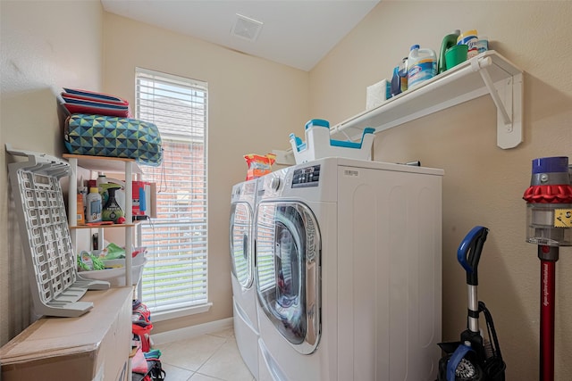 clothes washing area featuring separate washer and dryer, laundry area, light tile patterned flooring, and visible vents