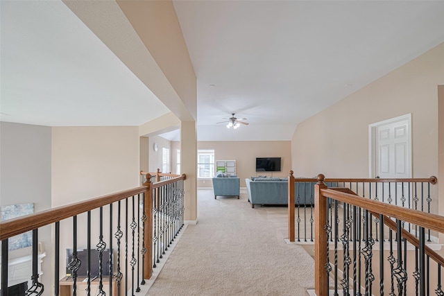 corridor with light carpet and an upstairs landing
