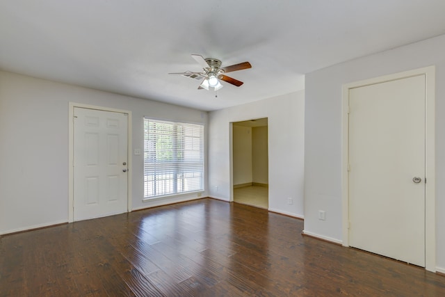 empty room featuring baseboards, ceiling fan, and wood finished floors