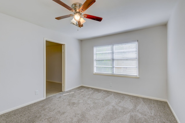 spare room with baseboards, carpet flooring, and a ceiling fan