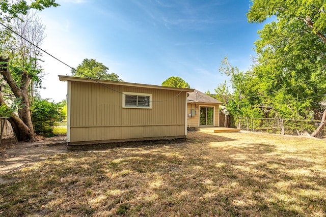 back of house featuring a lawn and fence