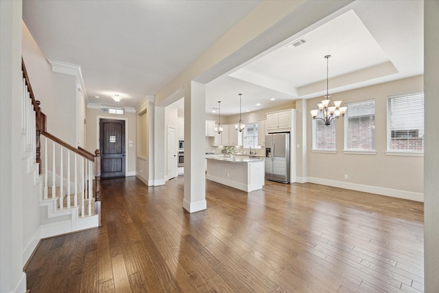 27018 Camirillo Creek Ln, Katy, TX 77494 - unfurnished living room with visible vents, stairway, baseboards, a chandelier, and dark wood-type flooring