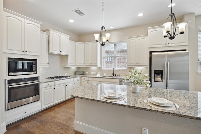 27018 Camirillo Creek Ln, Katy, TX 77494 - kitchen featuring a sink, white cabinets, a chandelier, and stainless steel appliances