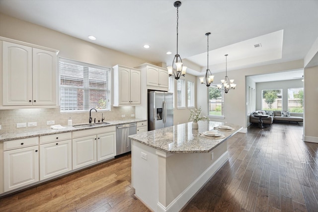 27018 Camirillo Creek Ln, Katy, TX 77494 - kitchen featuring a kitchen island, a sink, a chandelier, stainless steel appliances, and hardwood / wood-style floors