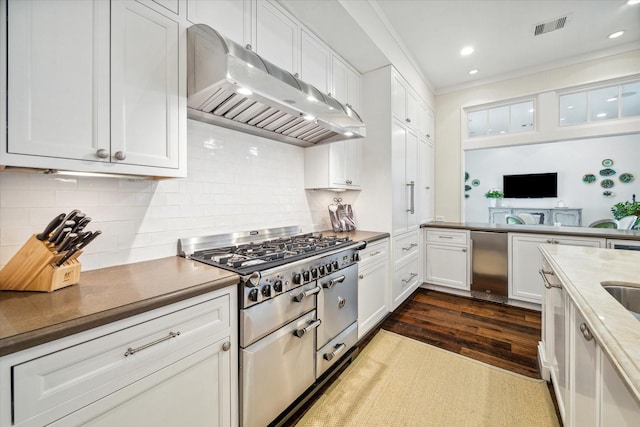 56 Audubon Hollow Ln, Houston, TX 77027 - kitchen featuring white cabinetry, tasteful backsplash, under cabinet range hood, visible vents, and dark wood-type flooring