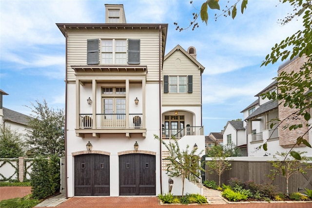 56 Audubon Hollow Ln, Houston, TX 77027 - view of front facade with a garage, fence, a balcony, and a chimney
