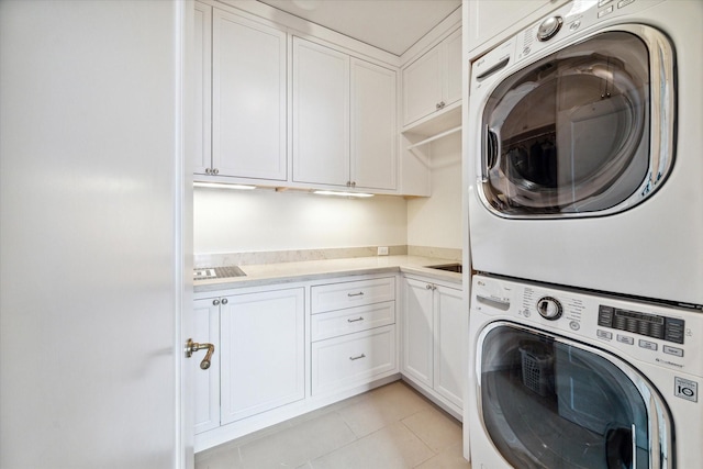 56 Audubon Hollow Ln, Houston, TX 77027 - laundry area with light tile patterned floors, stacked washer and dryer, and cabinet space