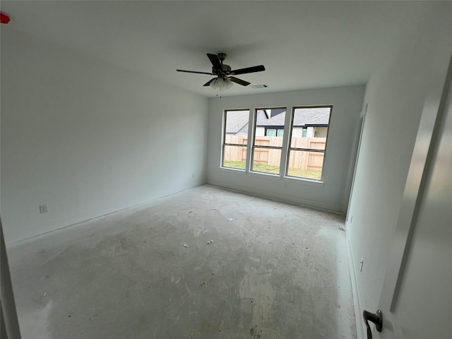 spare room featuring ceiling fan, concrete floors, and visible vents
