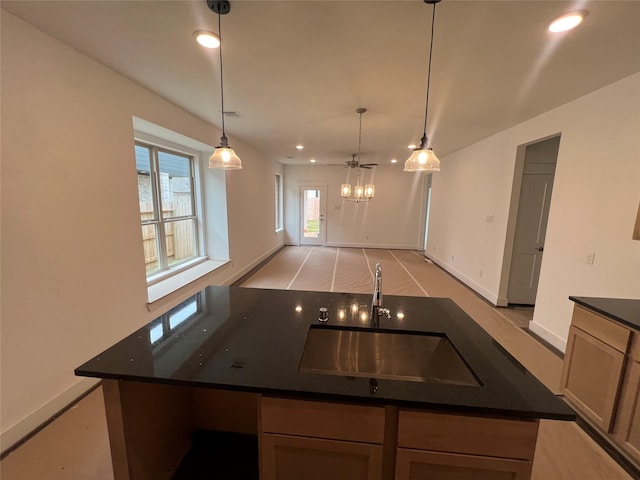 kitchen with decorative light fixtures, dark countertops, a sink, baseboards, and recessed lighting