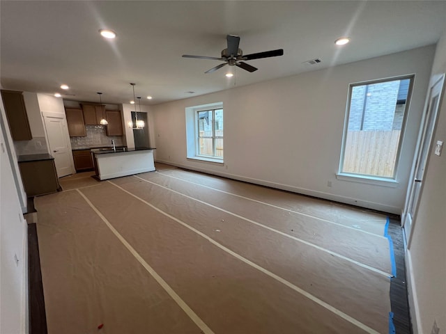 unfurnished living room featuring a sink, ceiling fan, recessed lighting, and visible vents