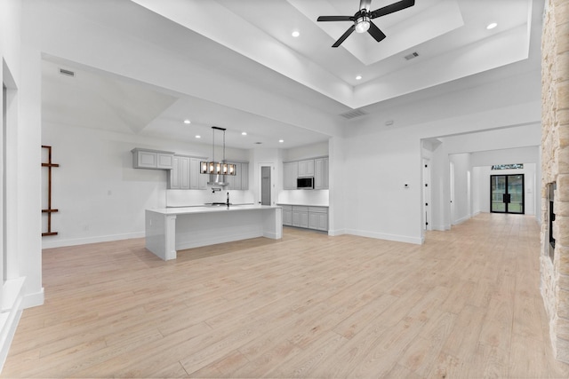 unfurnished living room with recessed lighting, ceiling fan, visible vents, and light wood finished floors