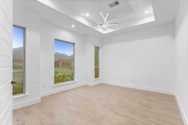 empty room with an inviting chandelier, recessed lighting, baseboards, light wood-type flooring, and visible vents