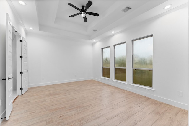 unfurnished room with ceiling fan, visible vents, a raised ceiling, light wood-style floors, and recessed lighting