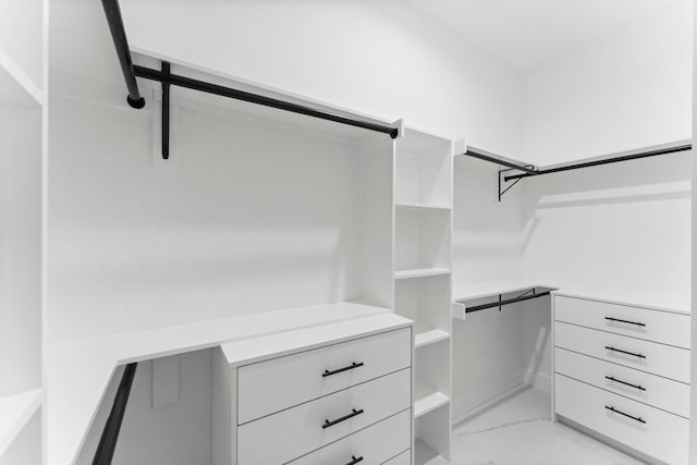 walk in closet with marble finish floor