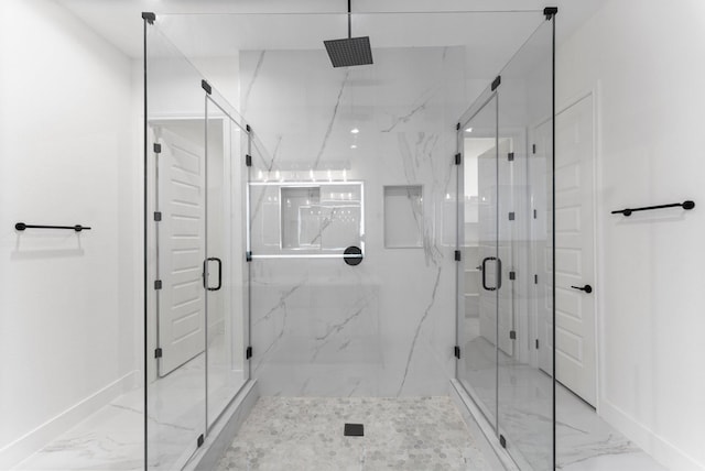full bath featuring baseboards, marble finish floor, and a marble finish shower