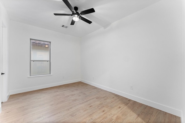 spare room featuring ceiling fan, visible vents, baseboards, and light wood-style floors