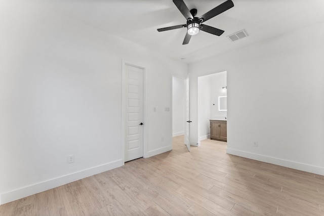 unfurnished bedroom with visible vents, connected bathroom, baseboards, and light wood-type flooring