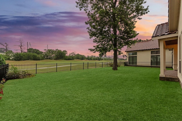 yard at dusk with a fenced backyard