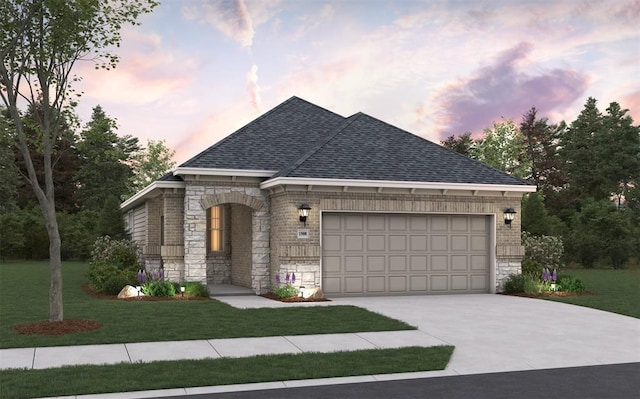 french country home with a shingled roof, an attached garage, a yard, and stone siding