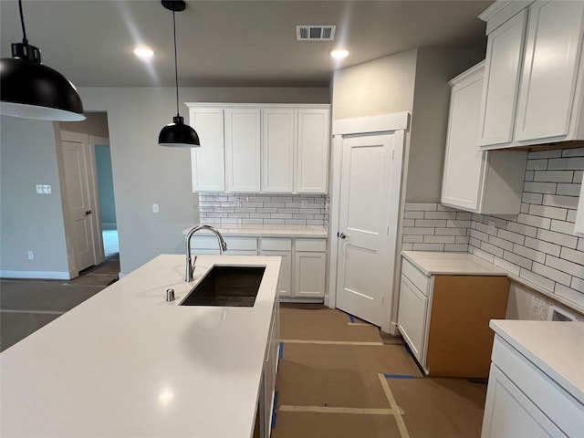 kitchen featuring visible vents, a sink, decorative backsplash, and white cabinets