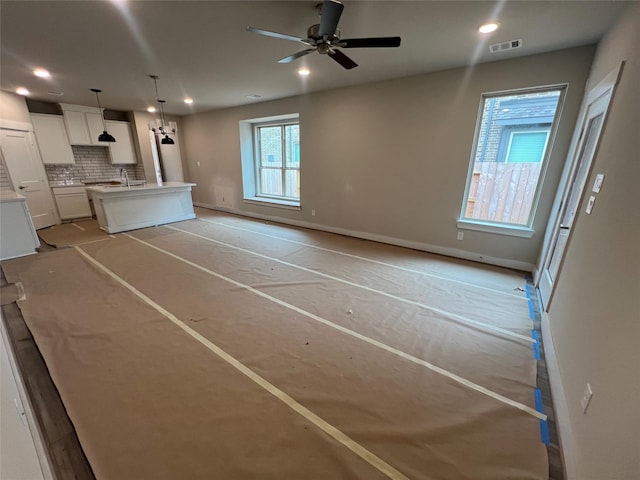 unfurnished living room featuring baseboards, ceiling fan, recessed lighting, and visible vents