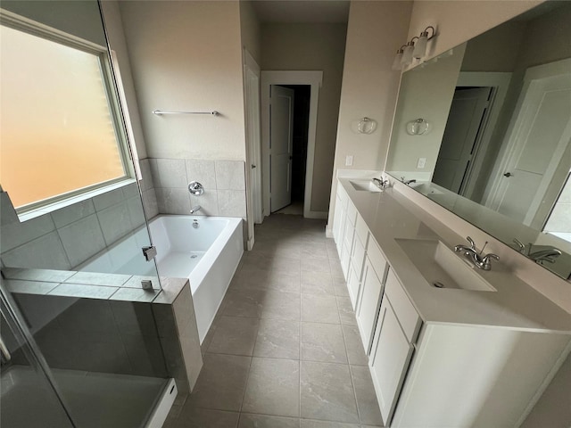 full bath featuring a sink, tile patterned flooring, double vanity, and a bath