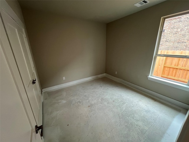 unfurnished bedroom with concrete flooring, baseboards, visible vents, and multiple windows