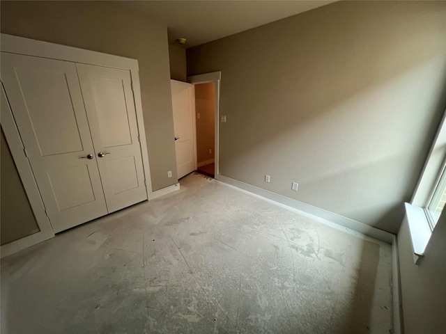 unfurnished bedroom with baseboards and a closet