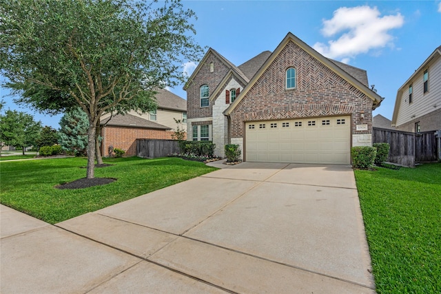 view of front of house with concrete driveway, brick siding, fence, and a front lawn